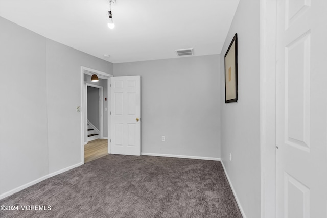 unfurnished bedroom with dark colored carpet