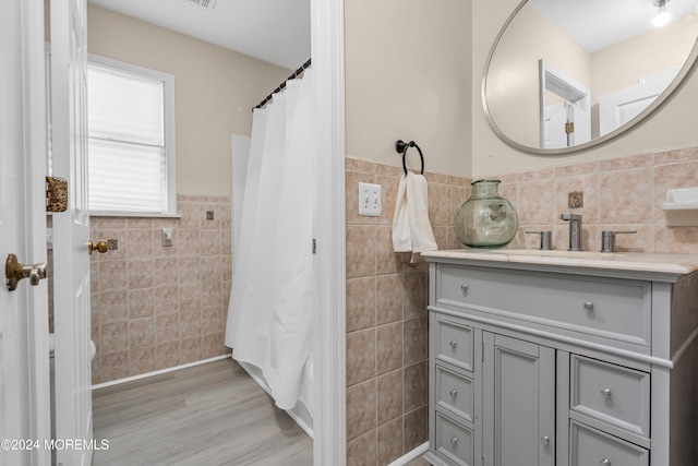 bathroom featuring vanity, tile walls, and wood-type flooring