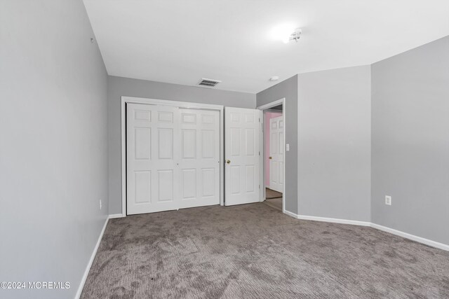 unfurnished bedroom with a closet and carpet floors