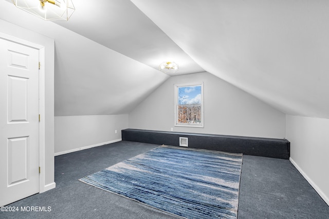 additional living space with lofted ceiling and dark carpet