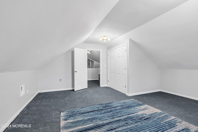 bonus room featuring vaulted ceiling and dark carpet