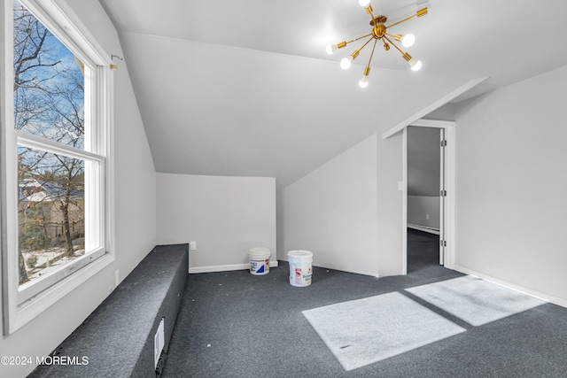 bonus room featuring a chandelier, lofted ceiling, and dark carpet