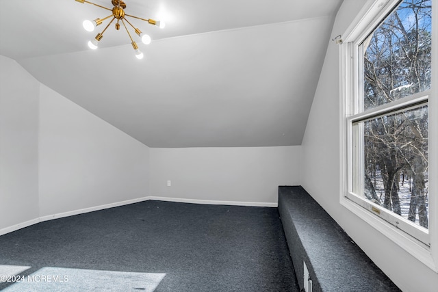 bonus room with lofted ceiling, an inviting chandelier, carpet, and a healthy amount of sunlight