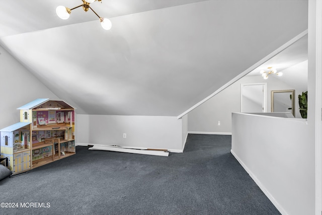 additional living space featuring dark colored carpet, a chandelier, vaulted ceiling, and baseboard heating