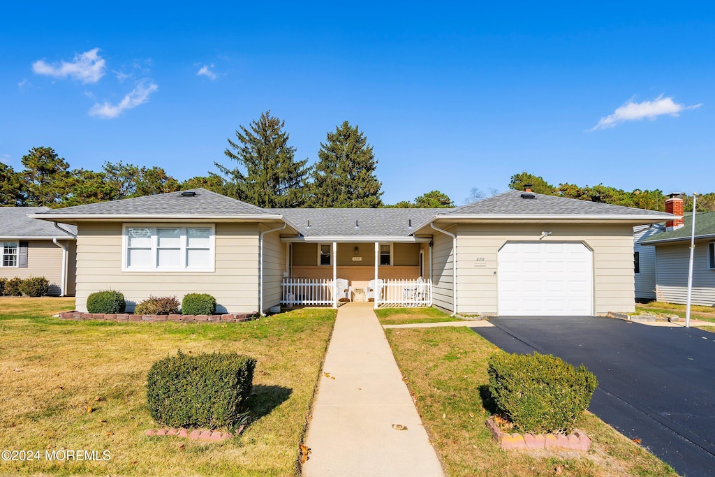 ranch-style home with a front lawn, a garage, and a porch