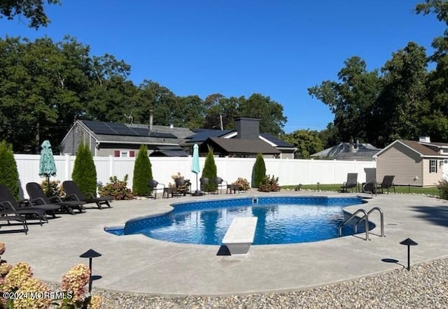 view of pool featuring a diving board and a patio area