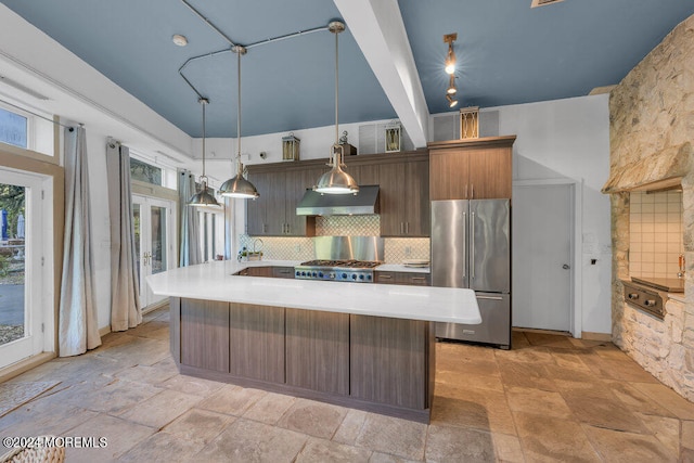 kitchen with pendant lighting, decorative backsplash, stainless steel appliances, and exhaust hood