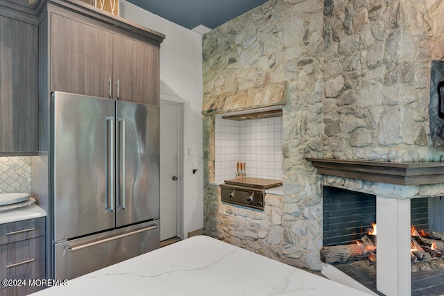 bedroom with a stone fireplace and high end fridge