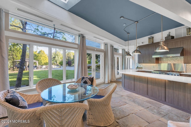 kitchen featuring french doors, pendant lighting, backsplash, extractor fan, and a high ceiling