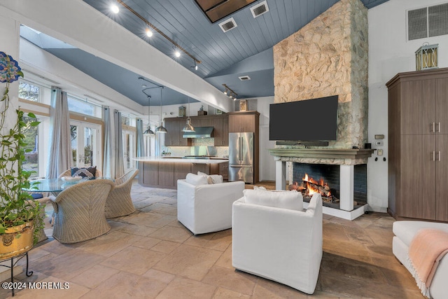 living room featuring wooden ceiling, a stone fireplace, and high vaulted ceiling