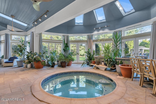 view of pool with a skylight and an indoor hot tub