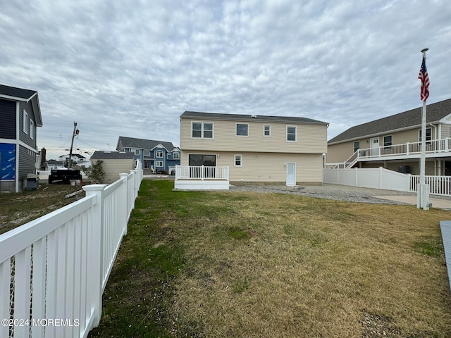 rear view of property featuring a lawn