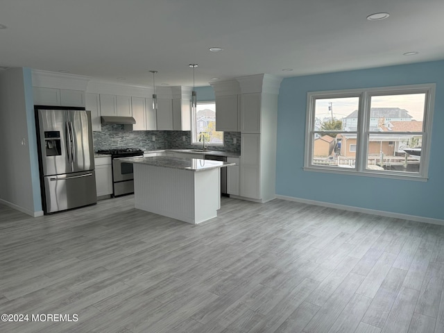 kitchen with a center island, stainless steel appliances, pendant lighting, white cabinets, and light hardwood / wood-style flooring