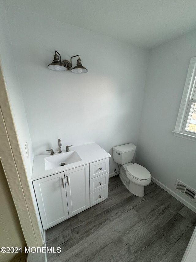 bathroom featuring toilet, vanity, and hardwood / wood-style flooring