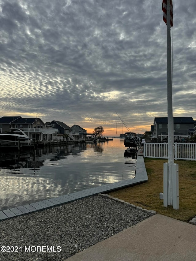 dock area with a lawn and a water view