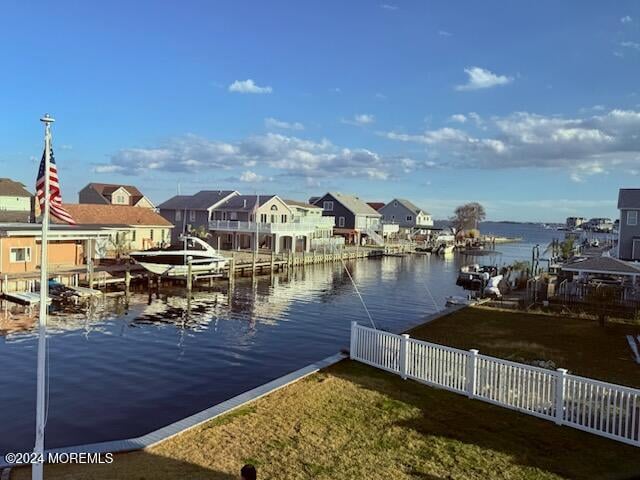 view of dock featuring a water view and a yard