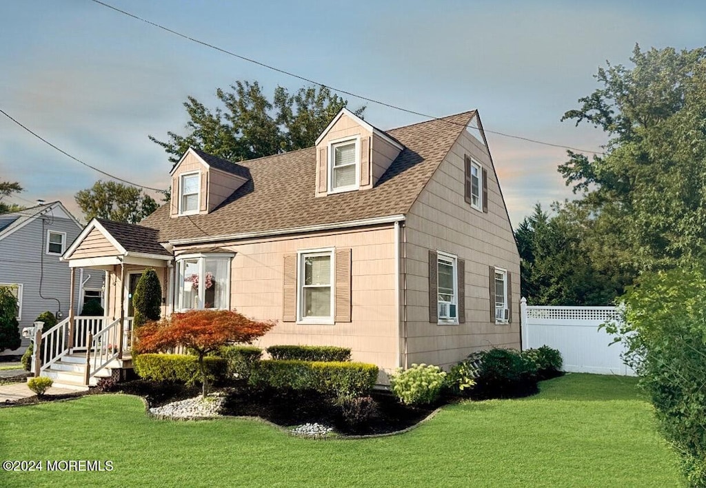 cape cod house with a front yard