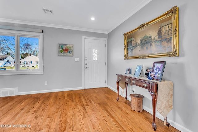 foyer entrance featuring ornamental molding and light hardwood / wood-style flooring