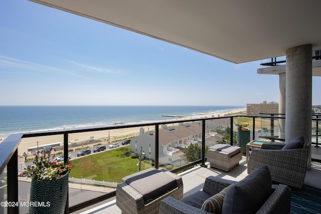 balcony featuring outdoor lounge area, a water view, and a beach view