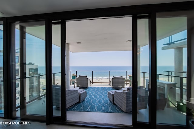 balcony featuring a beach view, an outdoor hangout area, and a water view