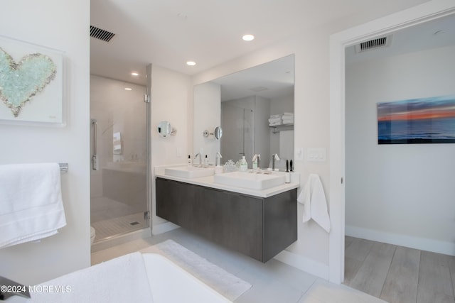 bathroom featuring hardwood / wood-style floors, vanity, and a shower with shower door