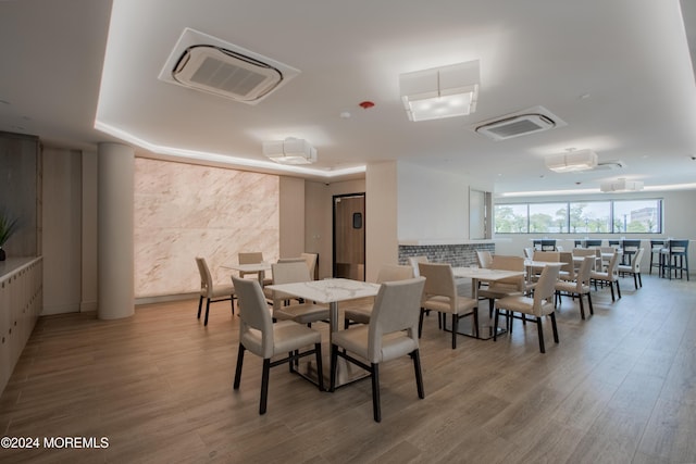 dining space with tile walls and light wood-type flooring