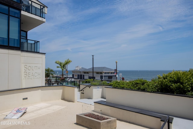 view of patio / terrace with a fire pit and a water view