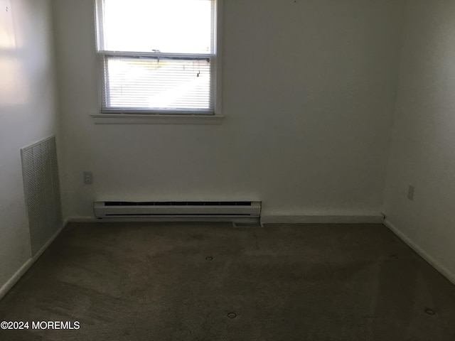 carpeted spare room featuring baseboard heating