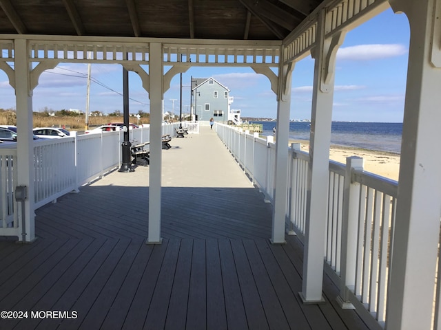 deck with a water view and a beach view