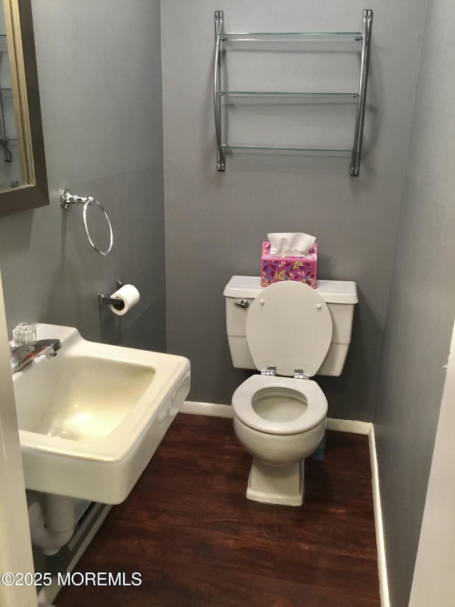 bathroom with sink, hardwood / wood-style floors, and toilet