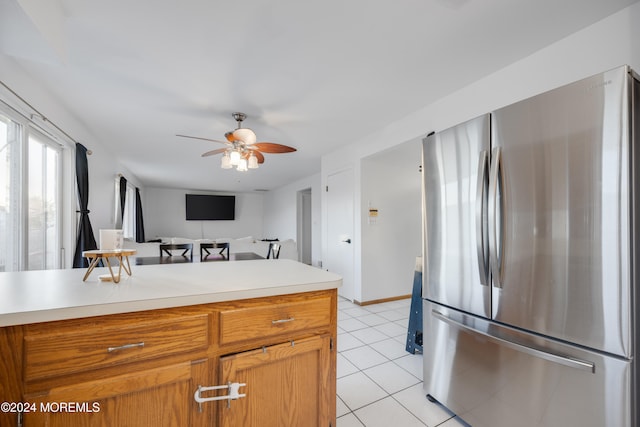 kitchen featuring light tile patterned floors, ceiling fan, and stainless steel refrigerator