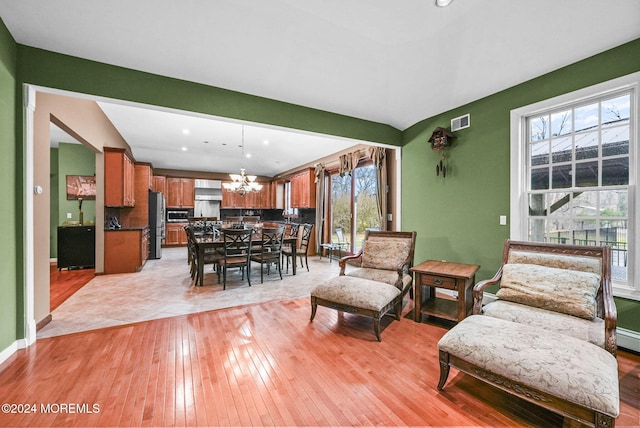 living room with light hardwood / wood-style flooring and a notable chandelier