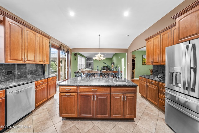 kitchen featuring stainless steel appliances, sink, decorative light fixtures, a notable chandelier, and lofted ceiling