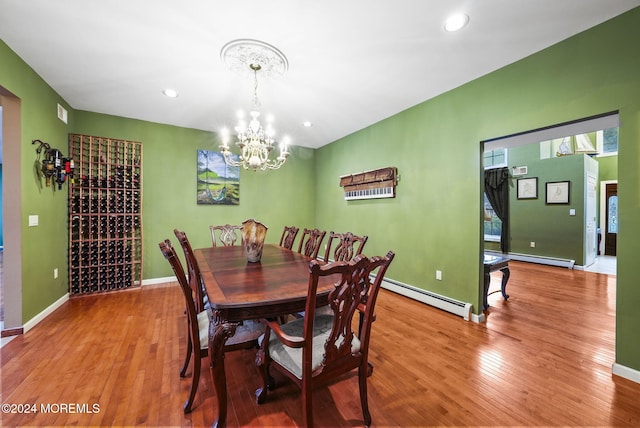 dining space with an inviting chandelier, a baseboard radiator, and hardwood / wood-style flooring