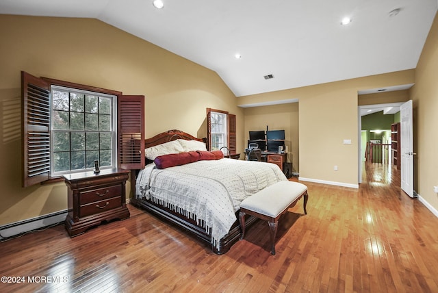 bedroom with light hardwood / wood-style floors, baseboard heating, and lofted ceiling