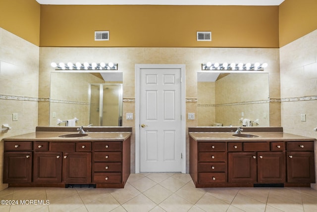 bathroom featuring tile patterned flooring, vanity, tile walls, and walk in shower