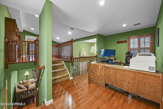 home office featuring hardwood / wood-style flooring, a notable chandelier, and lofted ceiling