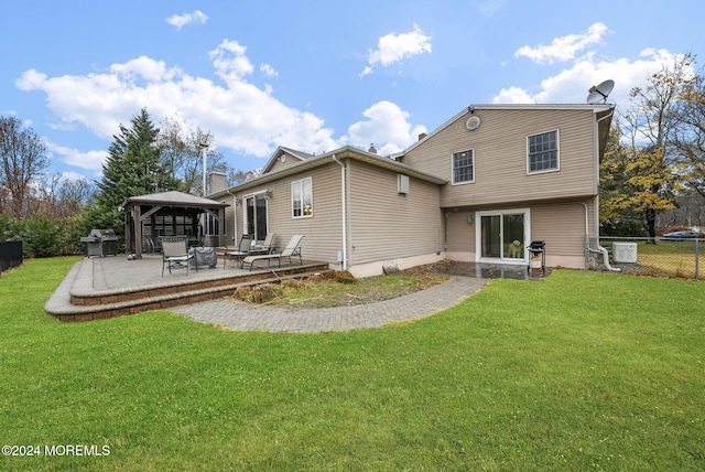 back of property featuring a gazebo, a yard, and central air condition unit