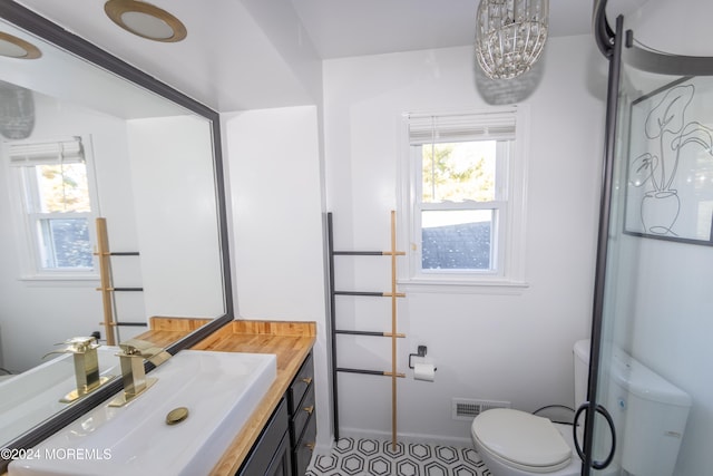 bathroom with vanity, a healthy amount of sunlight, and toilet