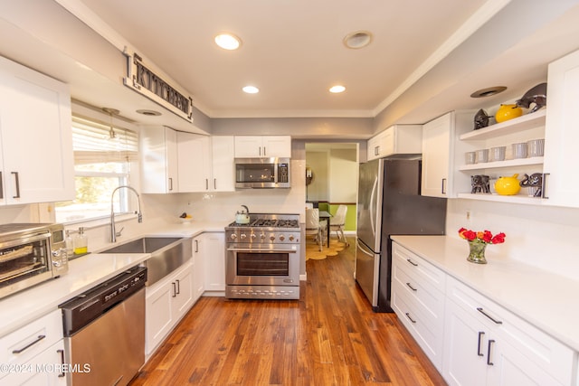 kitchen with stainless steel appliances, white cabinets, and dark hardwood / wood-style flooring