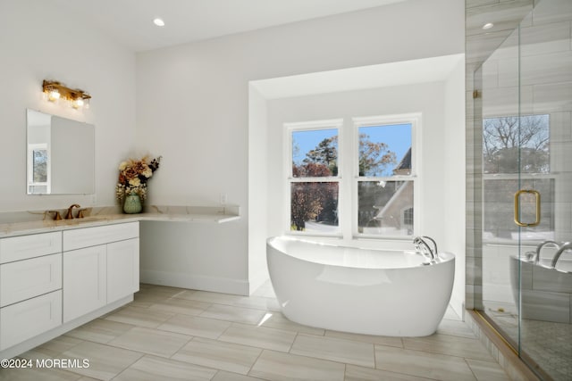 bathroom with vanity, separate shower and tub, and a wealth of natural light