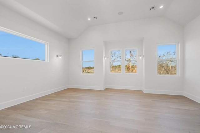 empty room featuring light wood-type flooring and lofted ceiling