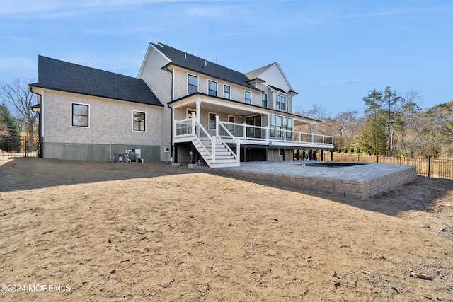 back of property featuring a wooden deck and a patio