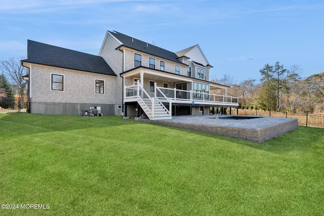 rear view of house with a lawn, a patio area, and a deck