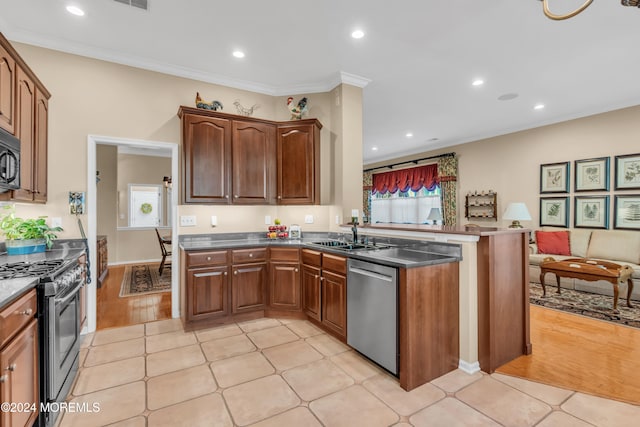 kitchen with kitchen peninsula, sink, crown molding, and stainless steel appliances