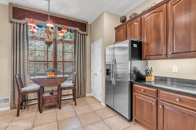 kitchen with an inviting chandelier, ornamental molding, light tile patterned flooring, decorative light fixtures, and stainless steel fridge