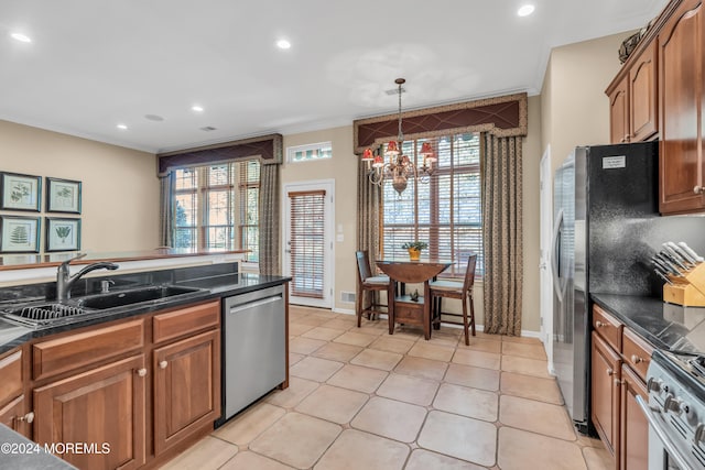 kitchen featuring sink, appliances with stainless steel finishes, an inviting chandelier, and a healthy amount of sunlight