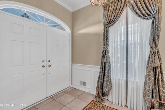 tiled entrance foyer featuring ornamental molding