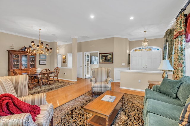 living room with a chandelier, hardwood / wood-style flooring, and ornamental molding