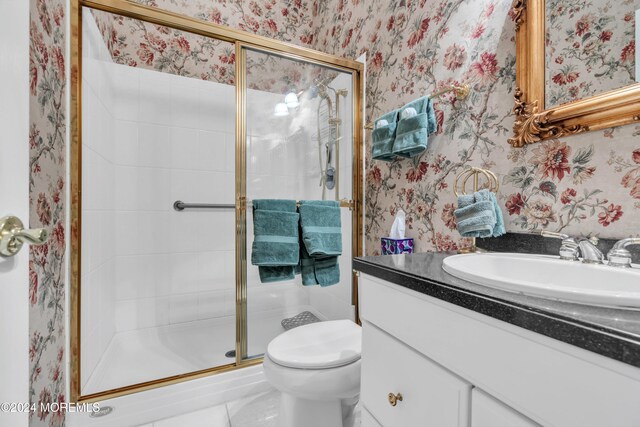 bathroom featuring vanity, toilet, and an enclosed shower